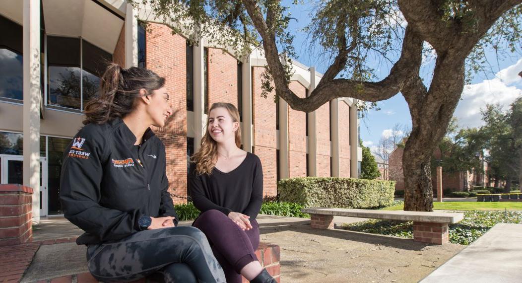 two students sit outside Wendell Phillips Center